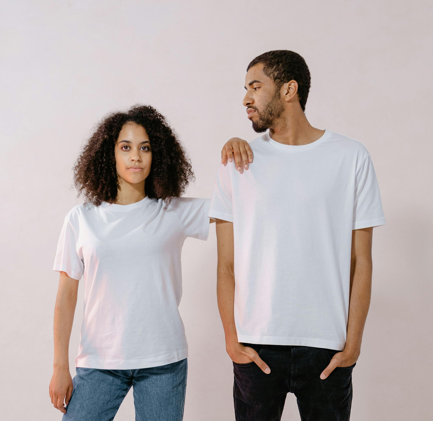Two models wearing plain white t-shirts, looking stylish